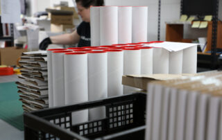 Workspace full of packages and carboard tubes ready to send