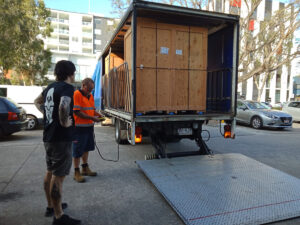 Truck unloading large wooden crate containing chromira 5X prolab