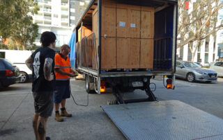 Truck unloading large wooden crate containing chromira 5X prolab
