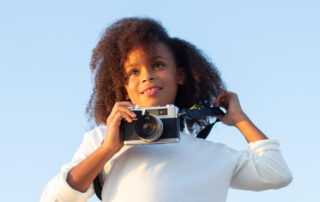 Young girl holding camera