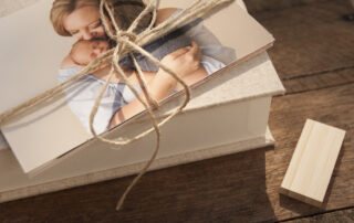 Pile of rag photo prints tied in jute string sitting on top of a natural linen portrait box