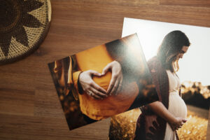 Pile of prints of pregnant woman on wooden table top printed on kodak professional endure lustre photo paper