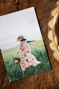 Heavily textured photographic aquarelle rag print of a woman standing in a grassy field