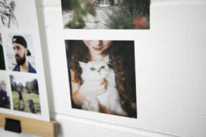 Close up of Sticker prints on a white brick wall next to a hanging printed instagram poster with ikea hangers