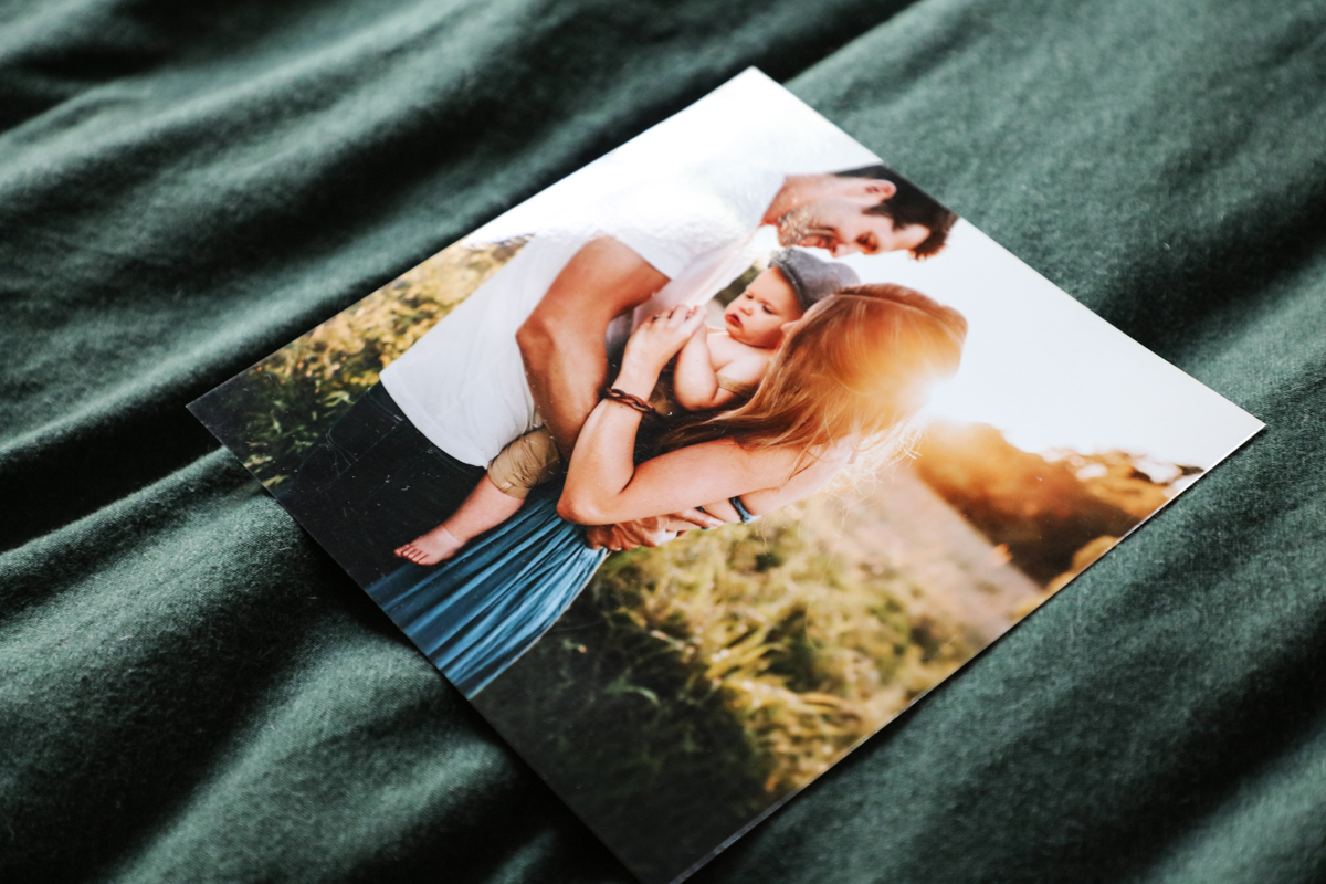 Glossy photographic print on a bed of a mum, dad and child