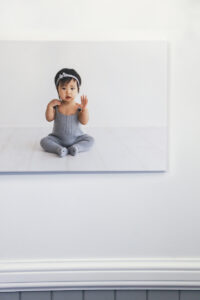 Image of a Asian baby girl on a 12mm lustre photo wrap hanging on a white wall with grey vj grooves