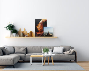 Cluster of photo wraps displayed on a floating shelf above a couch in a modern lounge room