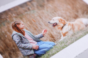 Photo of a girl and her dog printed on natural sustainable paper with a white border and torn edge