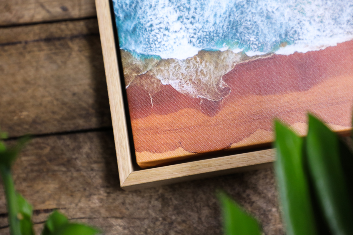 Corner of an oak float framed canvas print of a beach