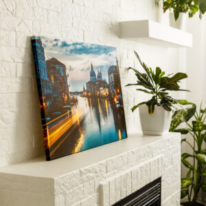 Stretched canvas photo print of a canal which is resting on a fireplace