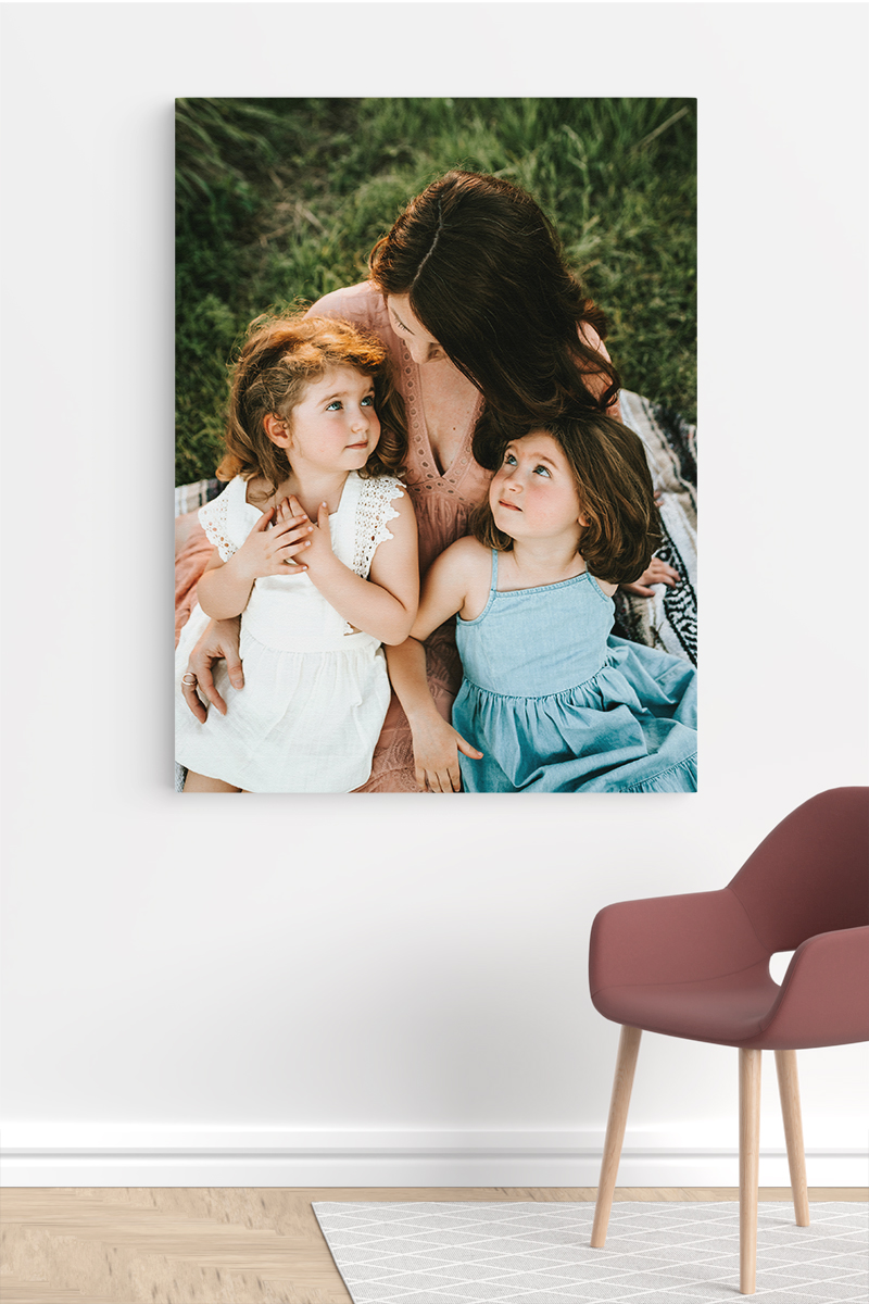 Streched canvas print of a mum and her daughters on a white wall in a modern room