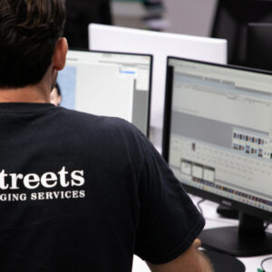 Streets imaging staff sits at computer processing school workflow
