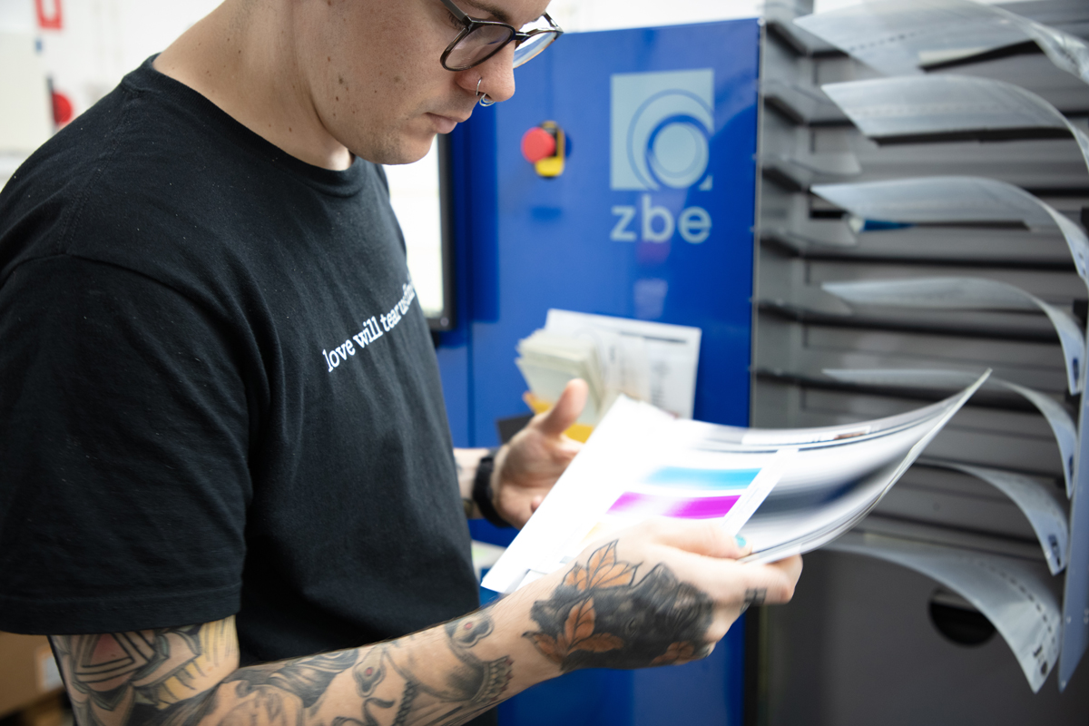 Lab staff checking over colour calibration test prints in front of ZBE printer