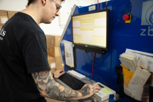 Man using densitometer and entering values into a computer on a ZBE printer