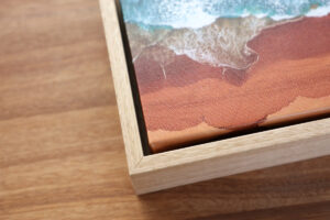 Corner of an oak float framed photo canvas of a beach