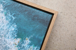 Corner of an oak float framed photo canvas of a beach