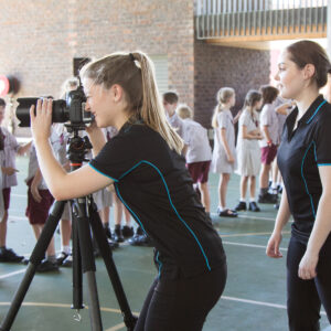 Photographers using a camera on a tripod to take school group photos