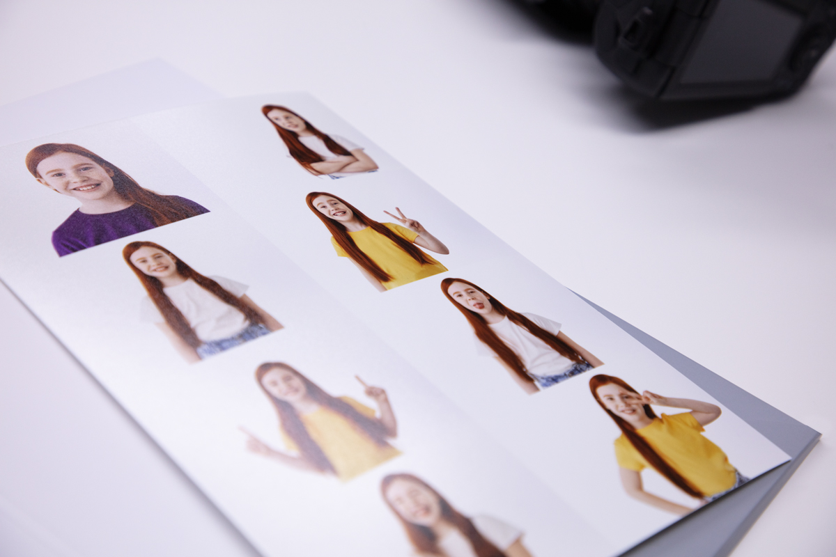 A print on a table with multiple different images layed up on the same print of a red haired girl