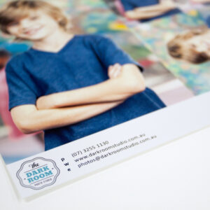 School package print on lustre photo paper with custom logo and details at the base sits on white table top