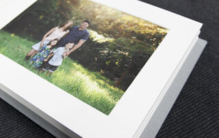 Linen photo album open to a page with a printed photo of a family standing in a field