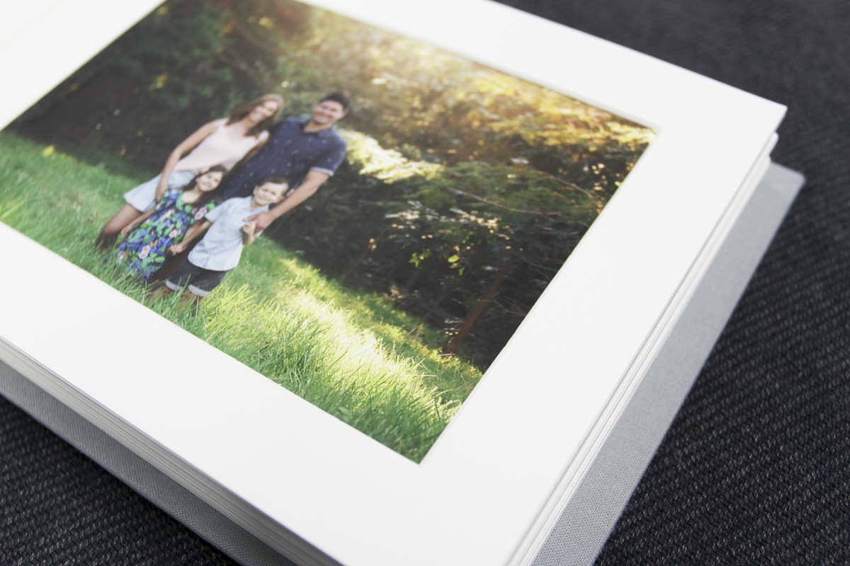 Linen photo album open to a page with a printed photo of a family standing in a field