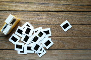 A box and a pile of 35mm Slide transparencies scattered over wooden table