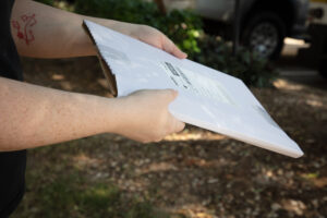 Young arms handing over a package outdoors