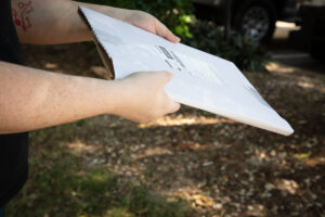 Young arms handing over a package outdoors