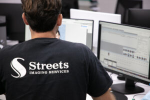 Back of Streets staff using computer to process school workflow